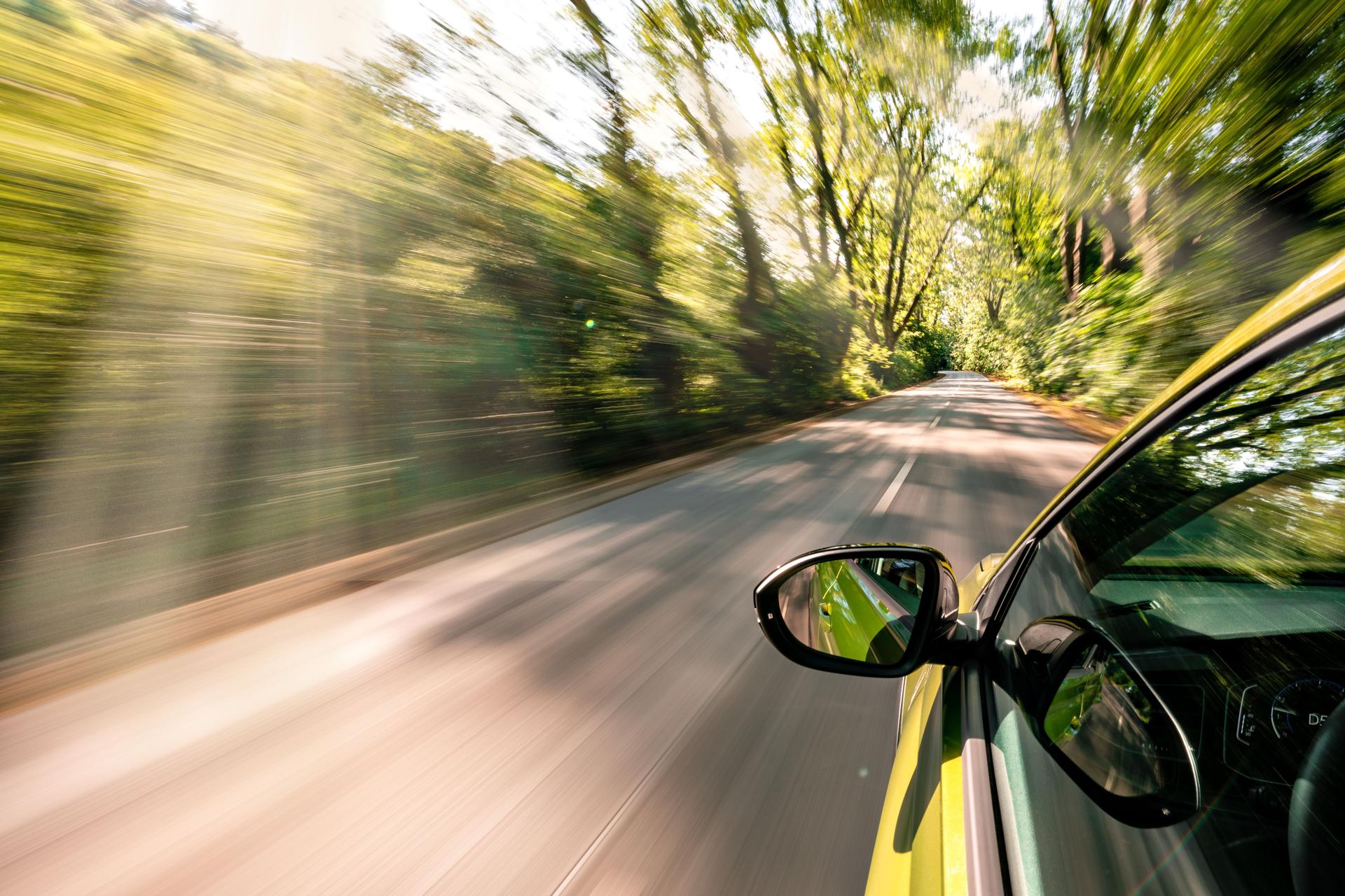 A car is driving on the highway, the environment is blurred
