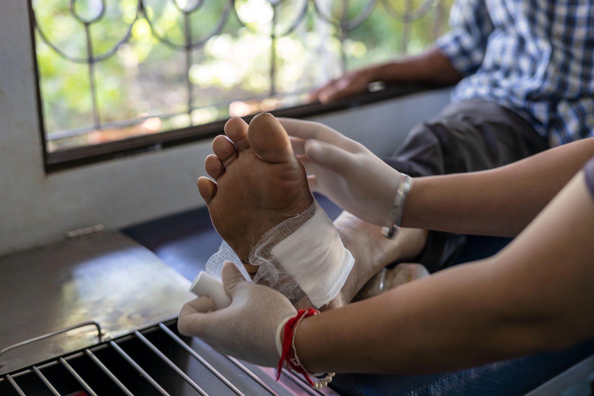 A nurse applies a bandage to an elderly foot.
